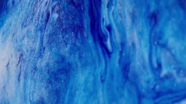 Parıltı karışımı. Parlak, ışıl ışıl bir doku. Odaklanmamış mavi pembe renkli simli boya parçacıkları soyut sanat arka planına sıvı dökülmüş..