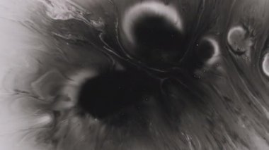 Boya damlası. Dökülen su. Odaklanamayan siyah beyaz renk akrilik arka plana dökülen kimyasal emülsiyon yuvarlak doku.