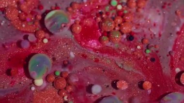 Parlak boya karışımı. Yağlı su dokusu. Odaklanmamış turuncu pembe renkli akrilik yuvarlak kabarcıklar soyut ve canlı arkaplanda yüzen sıvı simler..