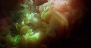 Paint flow. Shiny particles. Defocused pink yellow purple color glitter blend cloud spreading on abstract dark black art background.