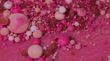 Sparkling paint. Oil fluid. Defocused pink orange white color ink glitter acrylic water bubbles shiny round texture floating on abstract background.