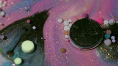Akrilik ışıltılı doku. Yağ kabarcıkları. Bulanık sarı mor renk, parlak parlak yuvarlak mürekkep, parlak su sıvısı soyut sanat arka planında yüzüyor..