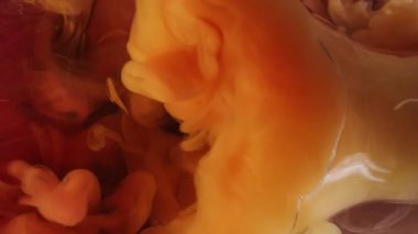 Kırık ampul. Buhar boyası. Odaklanmamış turuncu renk sıvısı soyut arkaplanda dumanı dolduran bardağı suya sıçratıyor..