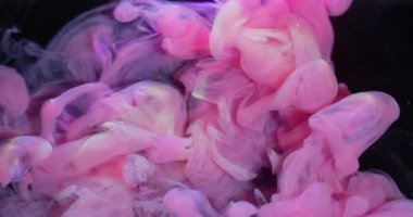 Bulut karışımı. Mürekkep sıvısı. Bulanık pembe, mor, sarı, dumanlı, parlak, kıvrımlı desen soyut, siyah arka planda yayılıyor..