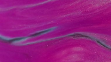 Akış sıçraması. Akrilik sıçrama. Soyut arkaplana yayılan parlak parçacıkların odağından çıkarılmış pembe altın renkli simler..