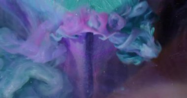 Boya döküldü. Bulanık boya dalgası. Pırıl pırıl mor turkuaz duman, sanat küpüne dökülüyor. Renkli su titreşimli karışık soyut arkaplan.