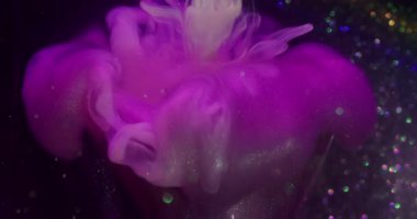 Bulut karışımı. Boya akışı. Odaklanamayan pembe parlak sıvı desen soyut koyu siyah bokeh arkaplan üzerindeki ampulü kırdı.