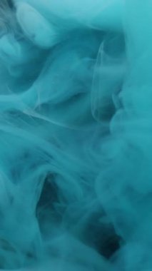 Dikey video. Sihirli duman. Boya karışımı. Mavi beyaz girdaplı gizemli dere. Renk pigmenti çözünen sanat soyut siyah arkaplan yüzen dalga çözünürlüğü.