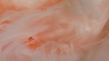 Boya karışımı. Parıldayan bulut. Odaklanmamış turuncu beyaz renk parlak akrilik sıçrama parlak doku soyut bokeh arka planda yayılıyor.