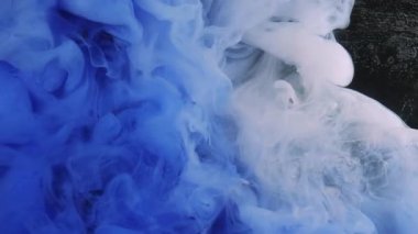 Buharda dönen mürekkep. Buhar arka planı. Sıvı suda mavi neon boya sanatın koyu siyah soyutlamasına yayılıyor..
