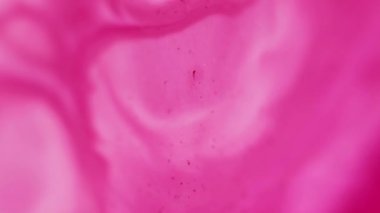 Mürekkep döküldü. Akrilik pigment. Odaklanamayan pembe lekeler soyut arka planda renk kimyasal akışı yayıyor.