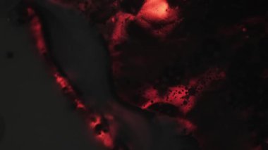 Soyut lav. Yüzen boya damlası. Siyah sanat dokusuna odaklanmış koyu pembe neon rengi su akrilik sıvı yağ akışı sıvısı.