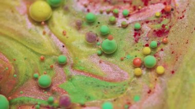 Sıvı damlayı boya. Mürekkep suyu. Bulanık yeşil kırmızı renkli yuvarlak yağ dokusu simli baloncuk akrilik akışı soyut arkaplanda yüzüyor.