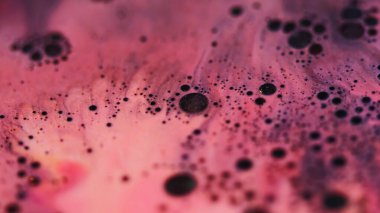 Parıldayan mürekkep. Leke sıvısı. Odaklanmamış pembe renkli su kombinasyonu. Soyut arkaplana yayılan kimyasal simli yağ damlası..