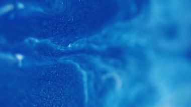 Akış sıvısı. Damla arkaplanı. Odaklanmamış mavi beyaz renk boya parıltılı su kabarcığı sıvı ıslak doku soyut diş minesi sanatı üzerinde akıyor..