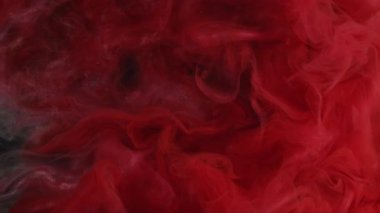 Arkaplanı boya. Renkli su. Odaklanamayan pembe kırmızı parıltılı girdap akışı kimyasal alev soyut kara sanata yayılıyor..