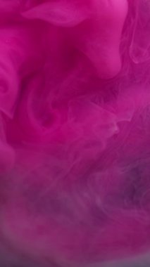 Dikey video. Bulut buharı. Mürekkebi karıştır. Bulanık pembe mavi renk su sıçratır dalgalı sis dokusu soyut koyu siyah arkaplanda daireler çizer..