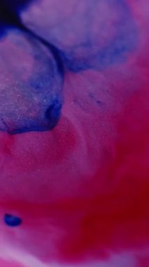 Dikey video. Karışık serpinti. Akan boya. Bulanık mavi mor mor renkli sıvı mermer parlak parçacıklar su sıvısı soyut arkaplanda yayılıyor.