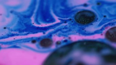 Köpüklü sıvı. Mermer dokusu. Soyut arkaplanda akan parlak emülsiyon yağ damlasında çözünmüş mavi pembe renk boya.