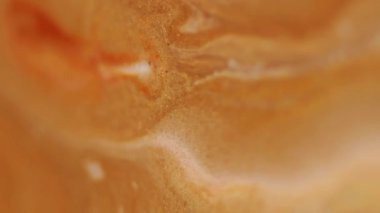 Mürekkep lekeleri. Parıldayan sıvı karışımı. Bulanık sarı, altın sarısı, parlak yağ rengi, sıvı akışı soyut sanat arka planına yayılıyor..