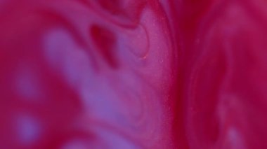 Dikey video. Dalga mürekkebi. Enamel sıvısı. Bulanık kırmızı neon akarsu sıvı kırmızı lekeler soyut sanat akrilik arka planda yayılıyor..