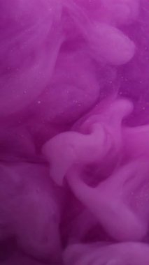 Dikey video. Mor sıçrama. Parıltılı boya. Bulanık leylak rengi su kıvrımlı sıvı ruhani buhar akrilik sıvı soyut arkaplanda yüzüyor..