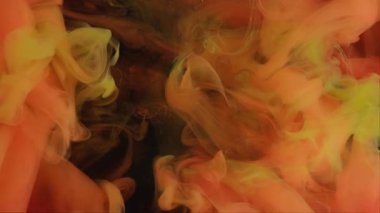 Mürekkebi karıştır. Duman suyu. Odaklanmamış turuncu renkli dumanlı duman boyalı ıslak sis soyut koyu siyah sanat arka planında büyüyor..