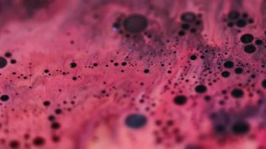 Parıldayan mürekkep. Leke sıvısı. Odaklanmamış pembe renkli su kombinasyonu. Soyut arkaplana yayılan kimyasal simli yağ damlası..