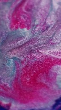 Dikey video. Parıldayan boya. Soyut mürekkep. Odaklanmamış kırmızı, mor renkli su, sanat arkaplanındaki parlak sıvı parçacıkları..