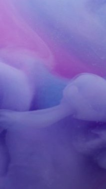 Dikey video. Boya karışımı. Mürekkep suyu. Soyut sanat arka planında çözünmüş mor mavi renkli kıvrımlı akrilik duman sıvısı buhar akışı.