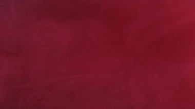 Parıldayan parçacıklar. Mürekkep akışı. Odaklanmamış kırmızı renk, soyut arkaplanda yüzen sıvı kimyasal pigment suyu..