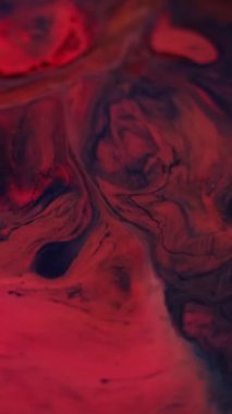 Dikey video. Mürekkep akışı. Akış sanatı. Su mermeri emülsiyon mavi lekeler soyut koyu siyah arkaplan üzerine yayılan koyu kırmızı kestane rengi..