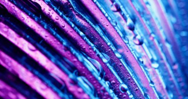 Islak doku. Çizgili parıltı söndü. Mor çizgiler, mavi arka planda parlaklık. Soyut neon kaplama cam yüzeyine renk suyu damlıyor.