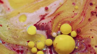 Mürekkep sıçraması. Akrilik boyalı su. Bulanık sarı kırmızı renk. Soyut yaratıcı sanat arka planında yüzen parlak parıltı balonu yuvarlak..