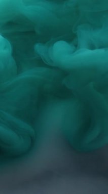 Dikey video. Boya buharı. Sıvı pigmenti. Odaklanamayan mavi beyaz renkli duman dalgası soyut sanat arka planında yüzen akrilik akım.