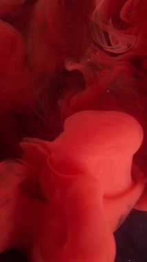 Dikey video. Dalga bulutu. Dönen duman. Odaklanmamış kırmızı renk akrilik boya su ruhani duman dokusu soyut koyu siyah sanat arka planında yüzüyor..