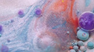 Boya karışımı. Petrol emülsiyonu dökülüyor. Odaklanmamış mor turuncu renkli köpük parlatıcı deseni soyut bokeh sanat arka planında yüzüyor..