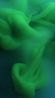 Dikey video. Bulut buharı. Mürekkebi karıştır. Odaklanmamış yeşil renk su sıçrama akrilik sis dokusu soyut arkaplanda daireler çiziyor.