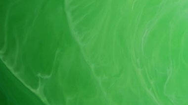 Damlama emülsiyonu. Boya damlası. Odaklanmamış yeşil renk soyut sanat akrilik yaratıcı arkaplan üzerinde dalgalı sıvı madde akışı sıçratır.