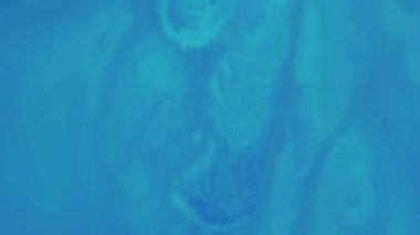 Dikey video. Mermer sıçradı. Soyut boya. Odaklanmamış mavi renk dalgalanma kimyasal doku su emülsiyon sıvısı sanat arka planında yüzüyor.