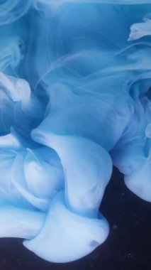 Dikey video. Mürekkep arkaplanı. Sıvı sıçraması. Odaklanamayan mavi renkli su kıvrımlı duman akrilik dokusu koyu siyah soyutlama üzerinde sallanıyor.