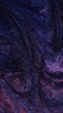 Dikey video. Parlak mürekkep. Dalgalanma dokusu. Bulanık mavi pembe renk su parıltılı sıvı parçacıklar soyut sanat arka planında akıyor..