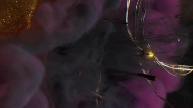 Kara buhar dağıldı. Işıl ışıl çelenkler. Simli toz ampulünde siyah pembe duman karışımı bulanık renkli mürekkep suyu soyut arka planda.