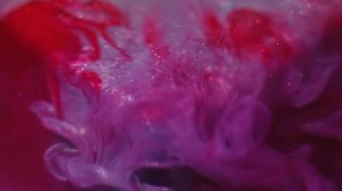 Mürekkep akışı. Görüntü pırıl pırıl akıyor. Sanat küpünde renkli akrilik girdap karışımı. Sequin parçacıkları pembe kırmızı sıvı soyut arkaplan.