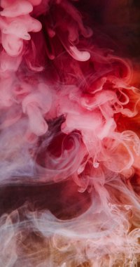 Boya dumanı sıçraması. Su altı sisi. Odaklanmamış turuncu pembe renkli bulut simli sıvı duman dokusu soyut arkaplana yayılıyor.