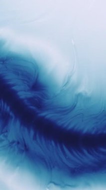 Dikey video. Akan mürekkep. Dökül bakalım. Odaklanmamış mavi beyaz renk soyut yaratıcı sanat arka planına sıçrama dokusu.