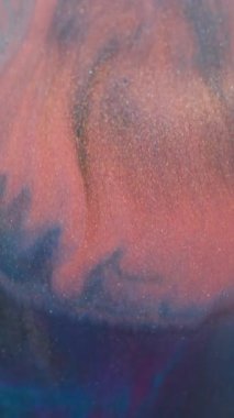 Dikey video. Bulanık mürekkep sıçraması. Mermer dokusu. Odaklanmamış turuncu mavi renk parıltılı su parlak parçacıklar soyut arkaplanda yayılıyor.