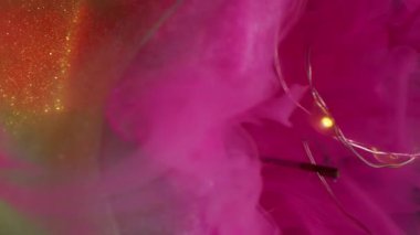 Buhar karışımı çözüldü. Kırık ampul. Fişek çelengine renk dumanı dökülmüş. Sarı parıltılı, soyut siyah arkaplanda pembe dumanlı boya karışıyor..