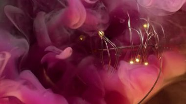 Buhar damlası. Mürekkep lekesi bulanıklığı. Cam ampulde renkli sıvı duman karışımı. Pembe parlak yeşil akarsu, çelenk soyut koyu arka planda dökülmüş..