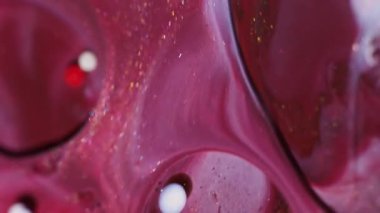 Parıldayan boya sıvısı. Mürekkep yağı suyu. Soyut akrilik zemin üzerinde yüzen kırmızı, beyaz, altın sarısı, yuvarlak, parlak, sıvı bir akış..